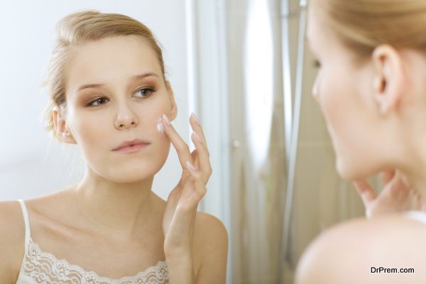 Young woman applying beauty cream, close up